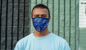 Man wearing a blue floral mask, showcasing a stylish approach to protection during the pandemic.