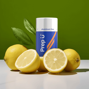 Prep U aluminum-free deodorant surrounded by fresh lemons on a vibrant green background.