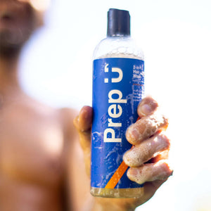Person holding Prep ü 2-in-1 hair wash bottle, perfect for effortless hair care and cleanliness.