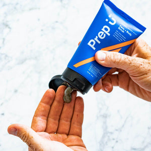 Person dispensing Prep U's French Green Clay Face + Body Scrub into hand for skincare routine.
