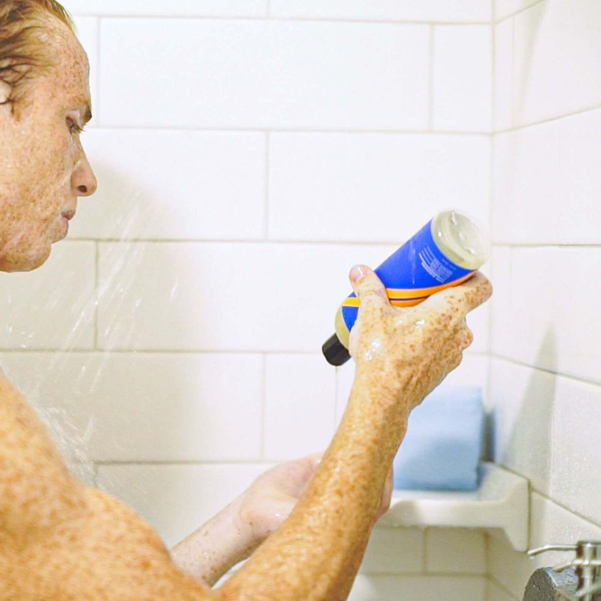 Teen guy in shower using shampoo, embodying the ultimate teen shower checklist for personal care.