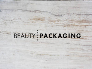 Stylish logo of Beauty Packaging on a textured stone background.