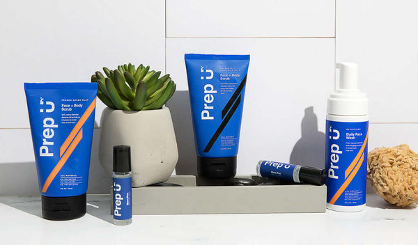 Skincare products arranged with a modern touch, featuring Prep U face and body care items in bold blue packaging.