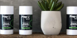 Three sticks of Prep U charcoal deodorant in citrus mint next to a succulent plant.