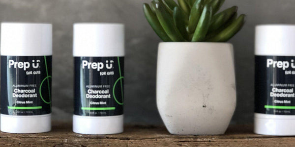 Three sticks of Prep U charcoal deodorant in citrus mint next to a succulent plant.