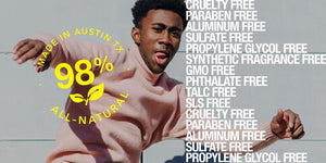 Smiling man in a pink sweater showcasing 98% all-natural, cruelty-free product ingredients.
