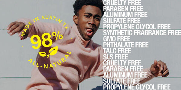 Smiling man in a pink sweater showcasing 98% all-natural, cruelty-free product ingredients.