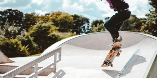 Skateboarder performing a jump at a skatepark, showcasing skill and excitement in the air.
