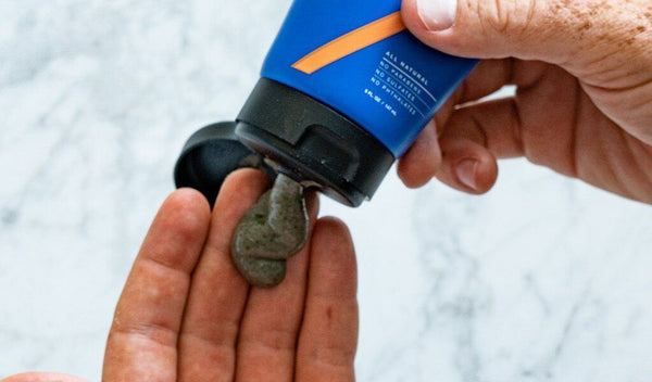 Squeezing a tube of Prep U Natural Deodorant to show the product's texture in a hand.