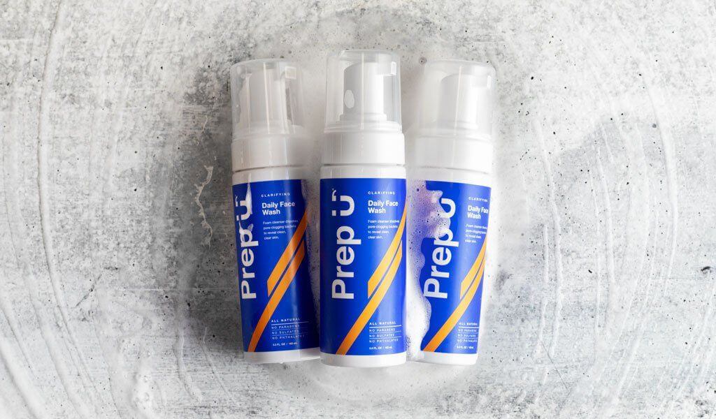 Three bottles of Prep u Daily Face Wash on a textured surface for men's skincare routine.
