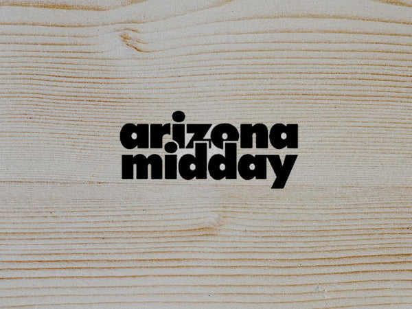Logo design for Arizona Midday on a wooden background, showcasing a stylish and modern look.
