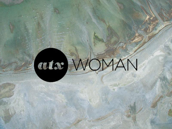 Stylish aerial view with the logo 'ATX Woman' overlaid on a textured landscape background.