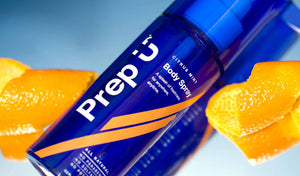A vibrant Citrus Mint body spray bottle surrounded by fresh orange slices, showcasing refreshing fragrance.