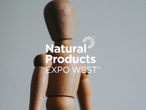 Wooden figure with Natural Products Expo West logo, showcasing creativity in natural product design.
