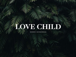 Stylish 'Love Child' logo on lush green leaves representing modern motherhood.