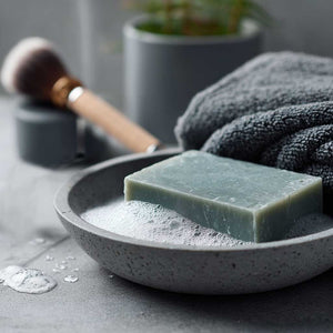 Alpine Shave Bar resting in a bowl, surrounded by bubbles and a soft towel, best shaving soap for sensitive skin.