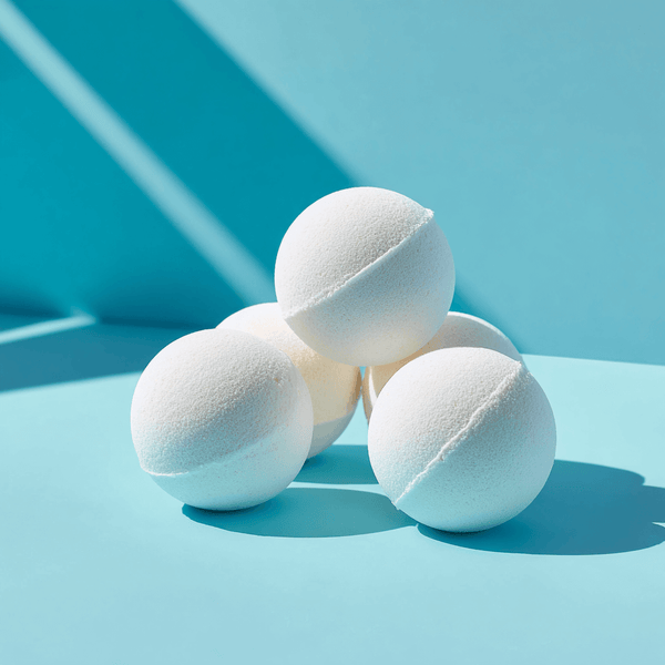 Five white muscle bath bombs stacked on a blue surface, perfect for post-workout relaxation and recovery.