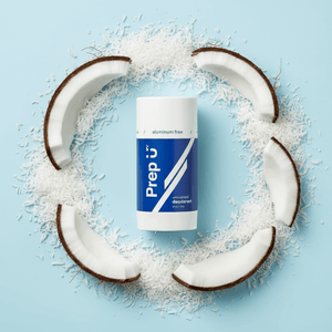Prep U Deodorant stick surrounded by coconut halves on a light blue background