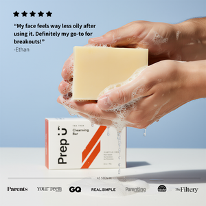 Hand holding a soap bar with 'Prep U' packaging against a light blue background
