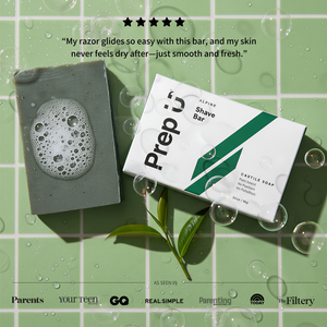 Shave bar with packaging on a green tiled background with bubbles and leaves.