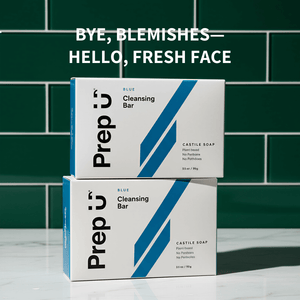 Two boxes of Prep U Cleansing Bar on a green tiled wall background with text 'Bye, Blemishes—Hello, Fresh Face'.