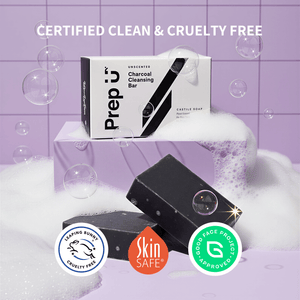 Two black soap bars with packaging on a purple tiled background, featuring certification logos.