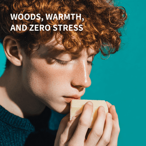 Teen holding a bar of soap with text 'WOODS, WARMTH, AND ZERO STRESS' on a teal background