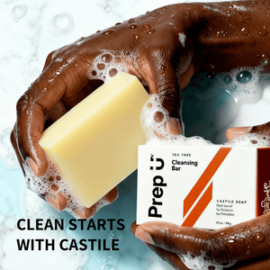 Hand holding a soapy bar with a 'Prep U' cleansing bar packaging in the background.