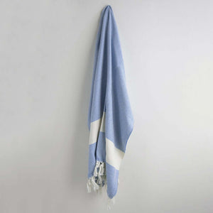 A blue and white Turkish towel with a diamond pattern, hanging on a wall | Prep U